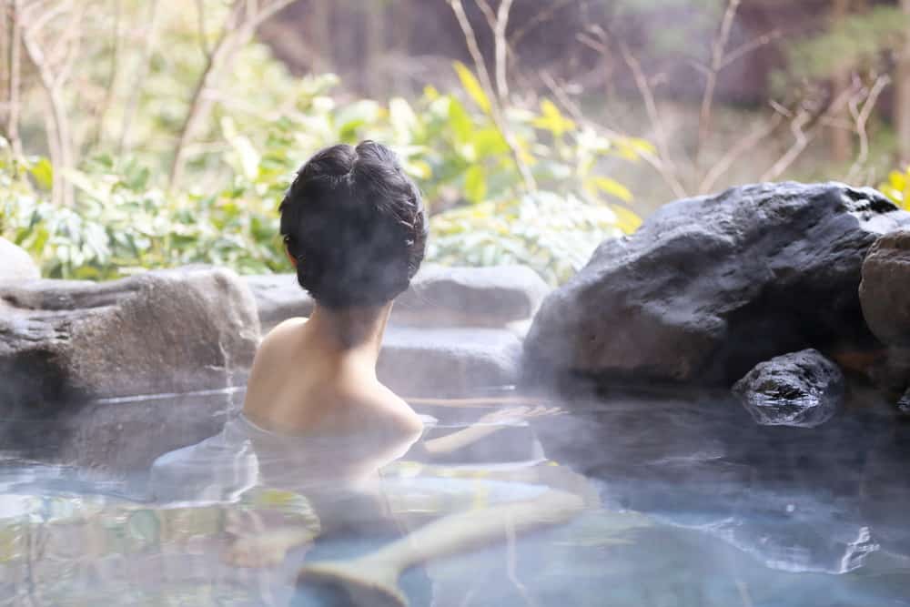 A japanese women relaxing in the natural hot spring. Feeling calm, peaceful, and relaxed.