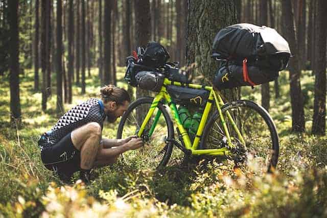 Man checking his bike during a great backpacking camping trip