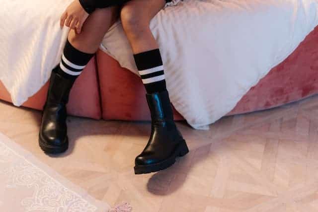 a girl is wearing black shoes and black socks