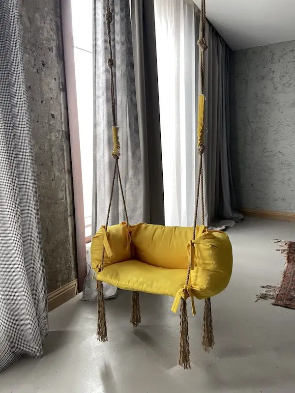 Yellow Indoor Hammock Near the Window with Curtains hanged from the ceiling