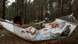men and women lying in a white hammock reading about underquilts so that they can better prepare.