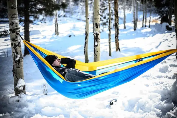 a person laying in a hammock in the snow