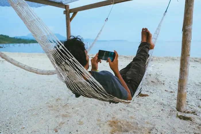 person on hammock using smartphone